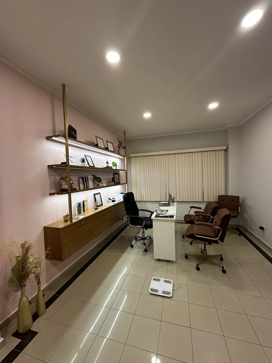 Consultório com a mesa de atendimento e a balança de bioimpedância